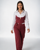 Ženski bordo komplet na pruge sa korsetom, belom košuljom i pantalonama, model hoda ka kameri.