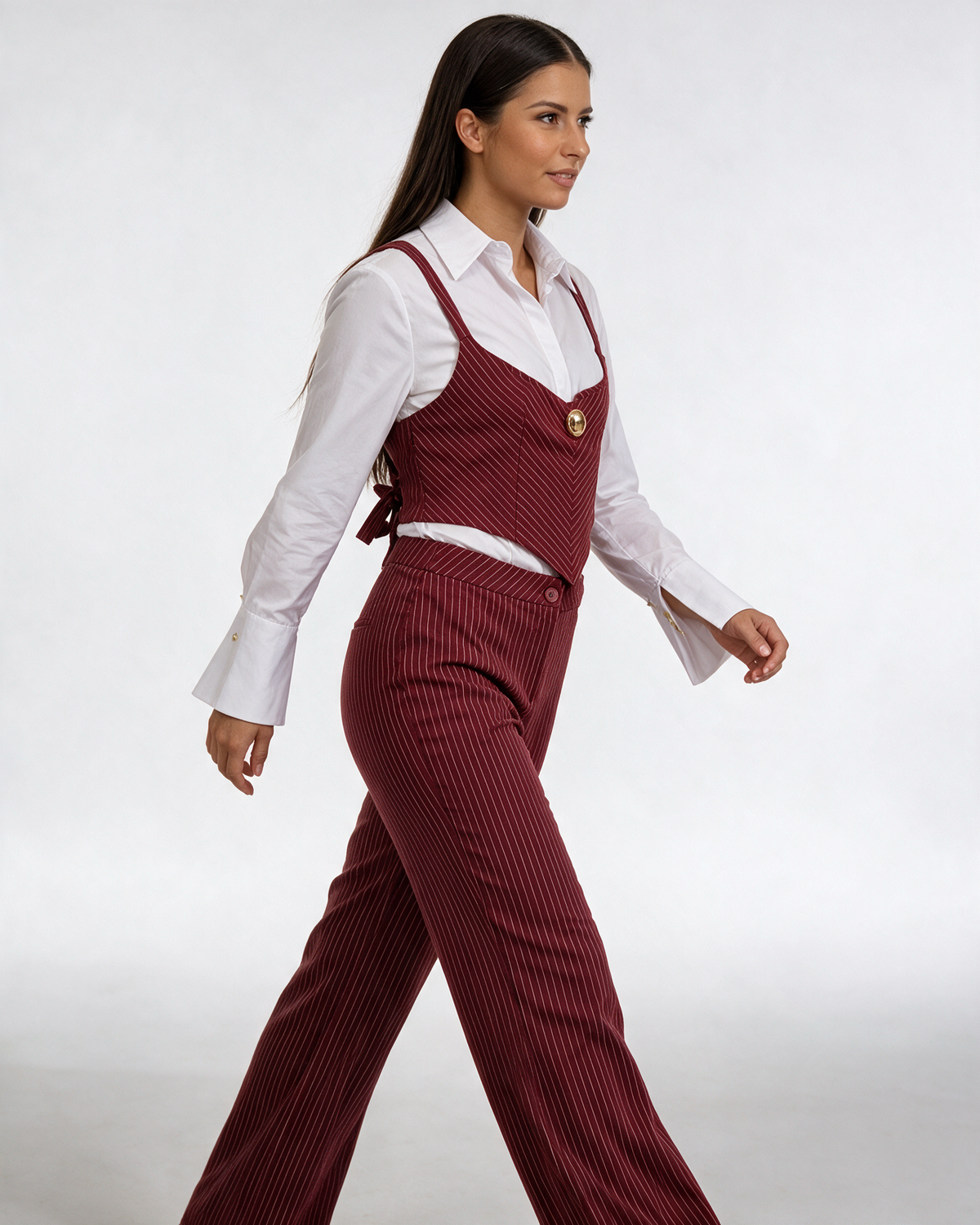 Ženski bordo prugasti komplet sa korsetom, belom košuljom i pantalonama, model u profilu.