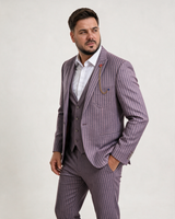 Male model in a bordo three-piece striped suit, standing in a studio with one hand in his pocket.