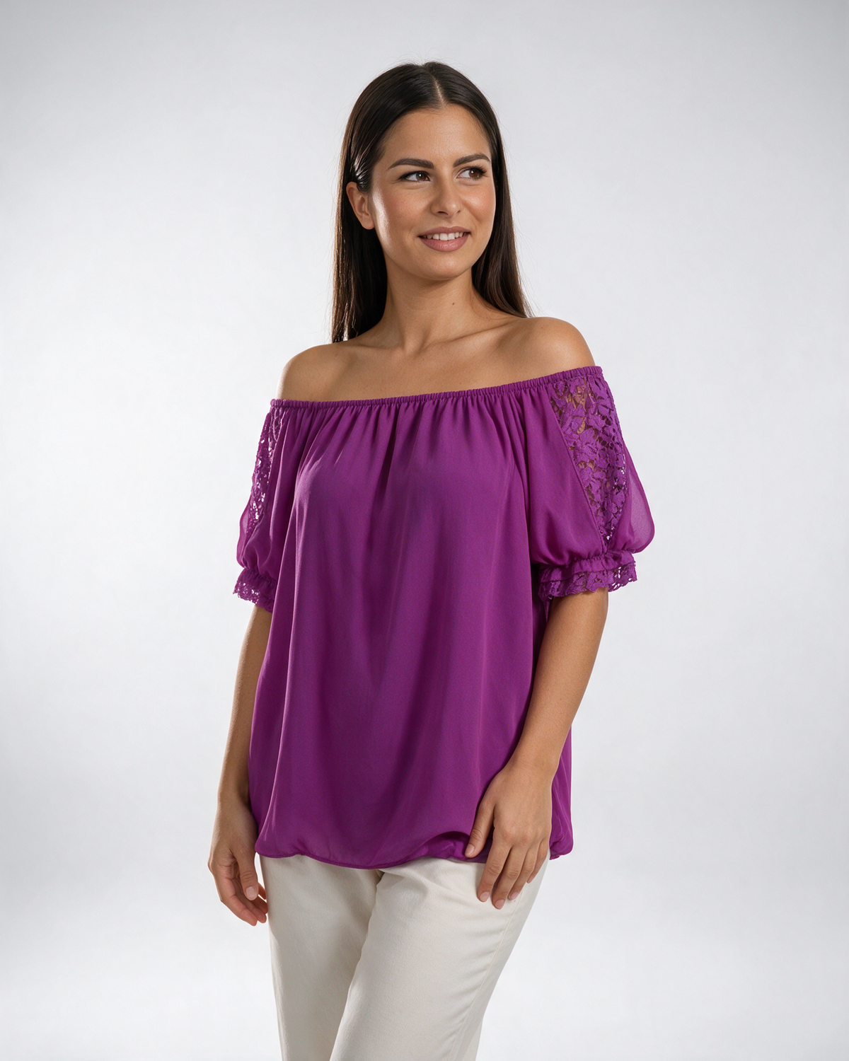 Ženska ciklama bluza od šifona sa čipkanim rukavima, spuštenim ramenima i elastičnim porubima, stilizovana uz pantalone.