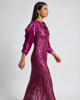 Ženska ciklama haljina sa šljokicama u talasima i širokim satenskim rukavima, dužine do kolena, uz telo.