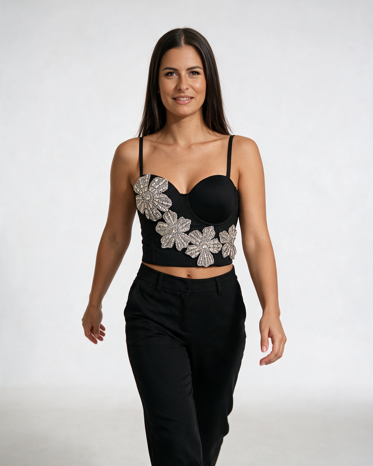 Crni bustier top sa oblikovanim korpicama, podesivim bretelama i velikim cvetovima od kristala na prednjoj strani.