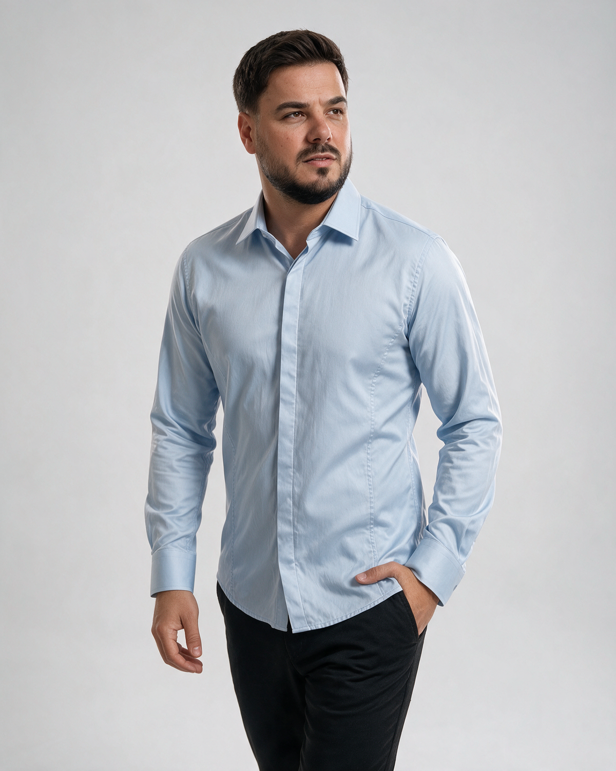 Muška košulja led plave boje sa skrivenim kopčanjem, satenskim sjajem i slim fit krojem, model u crnim pantalonama.