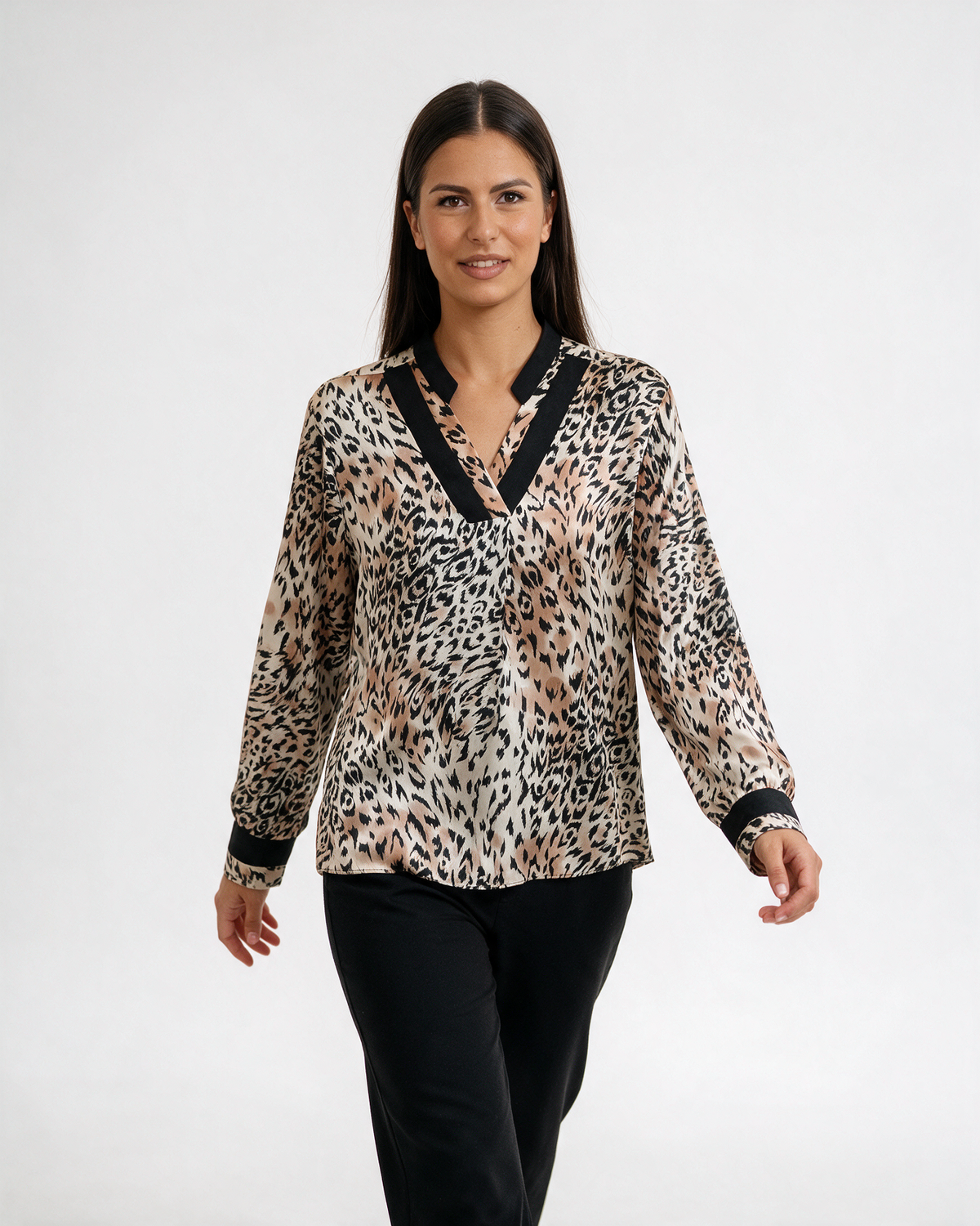 Ženska leopard bluza sa crnim V izrezom i crnim manžetnama, dugih rukava, nošena uz crne pantalone.