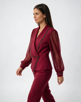 Crveni ženski komplet sa resama od perli, sako na preklop i pantalone, model u profilu na beloj pozadini